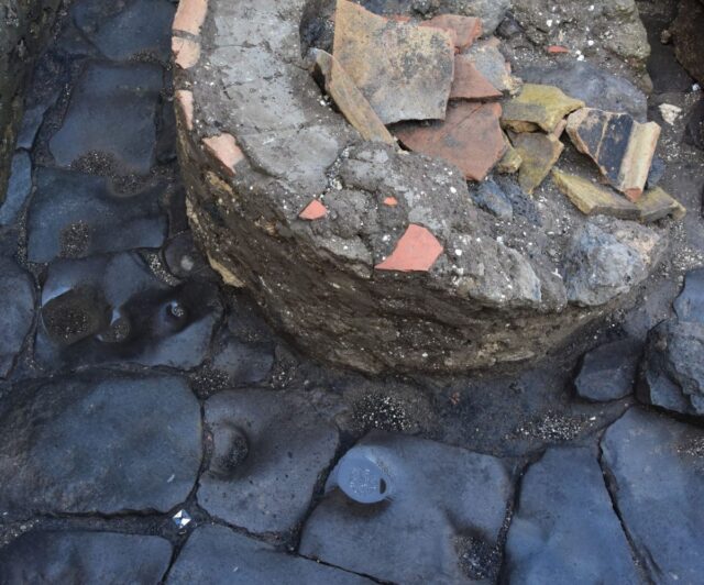 View of a beaten rock path and a cylindrical structure in ruins. 