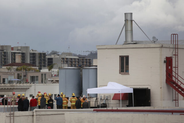 First responders standing on the roof of the Cecil Hotel, near its water tank