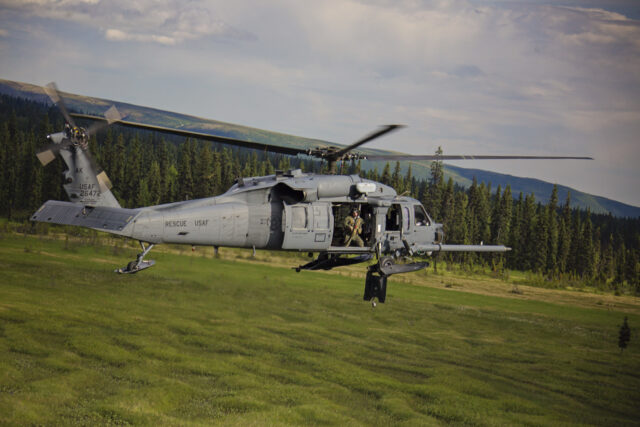 A helicopter flying over a field.