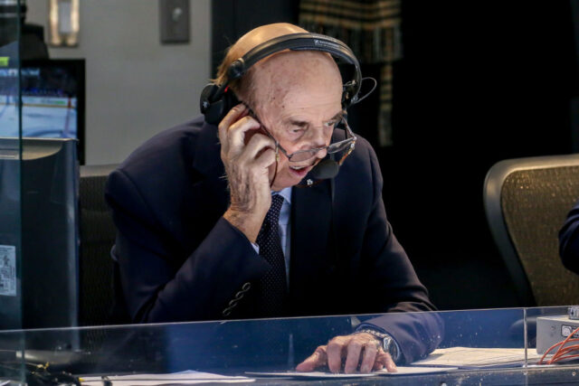 Bob Cole sitting at a desk with commentator gear on his head