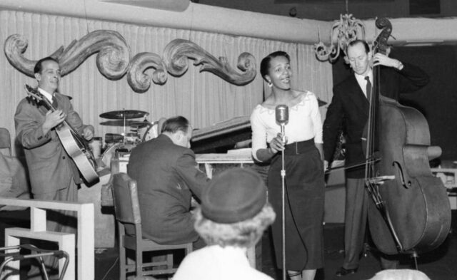 Eleanor Collins performing on stage with her band