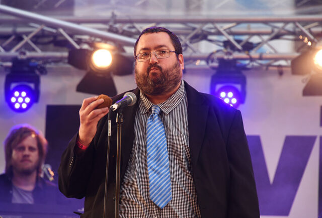 Ewen MacIntosh speaking into a microphone while on stage