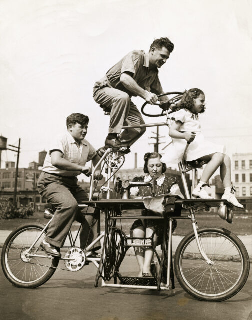 Four people driving a single bicycle.