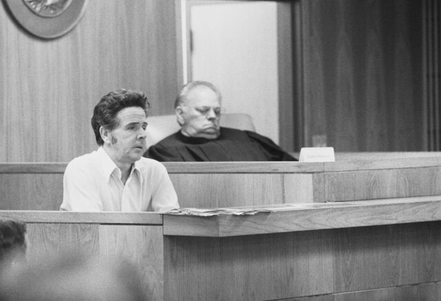 Henry Lee Lucas on the stand in court flanked by Judge W. C. Boyd.