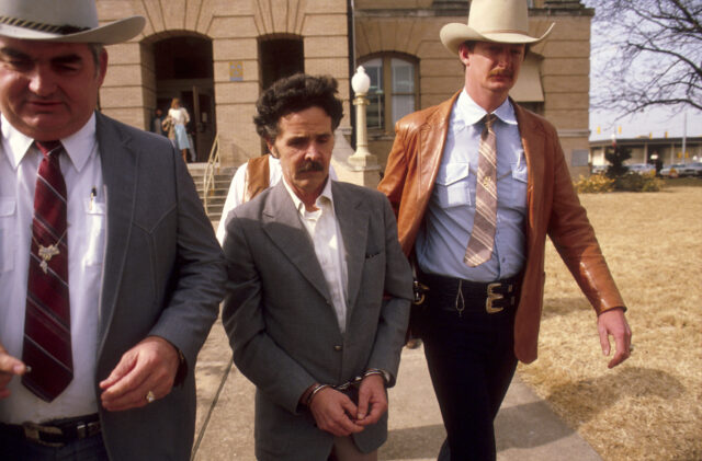 Henry Lee Lucas is being walked to jail by Texas Rangers.