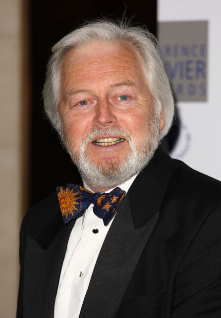 Ian Lavender standing on a red carpet