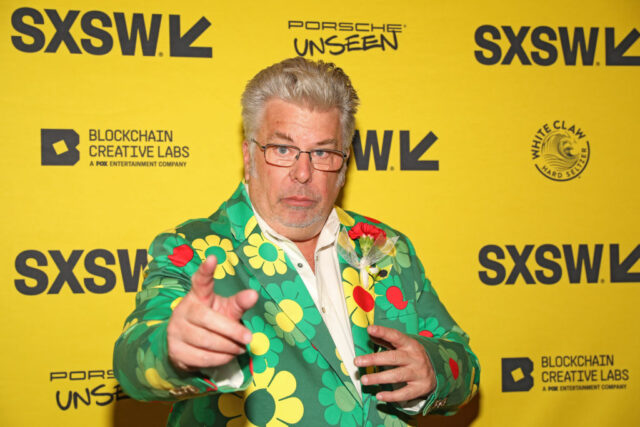 Mojo Nixon standing on a red carpet