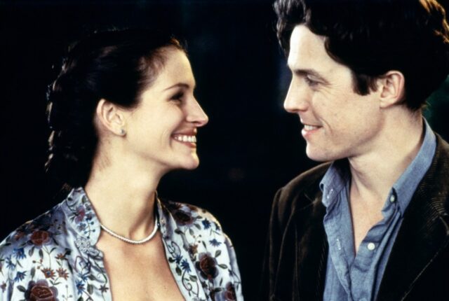 Julia Roberts and Hugh Grant smiling at one another.