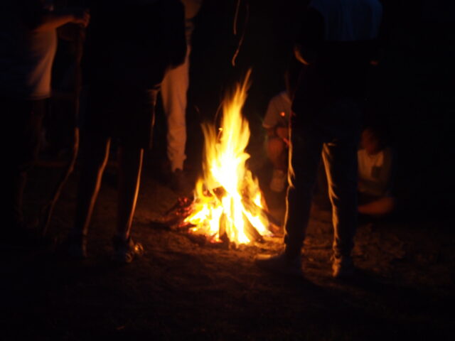 People standing around a campfire.