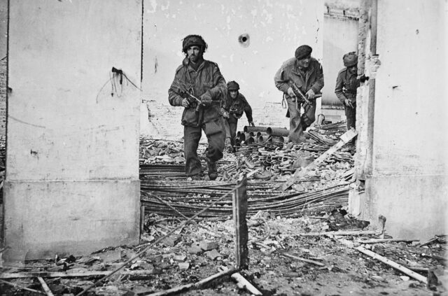 Soldiers walking through debris.