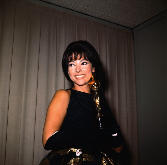 Rita Moreno holding her Oscar statuette.