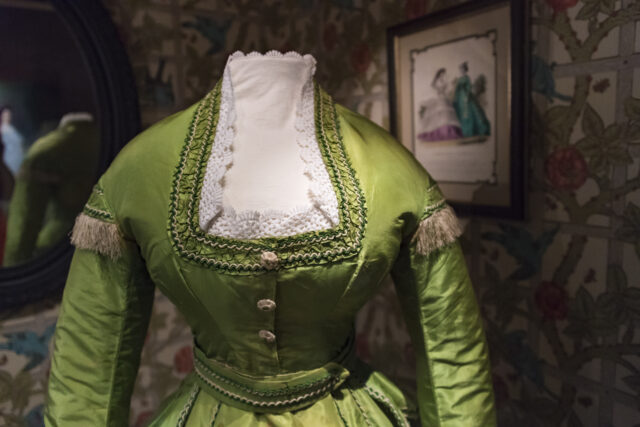 A green silk dress on a mannequin.