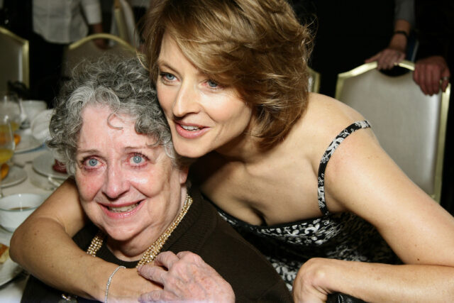 Jodie Foster hugging her seated mother from behind.