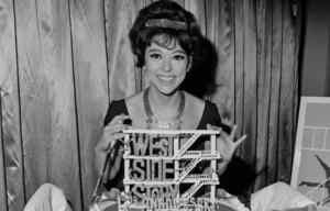 Headshot of Rita Moreno in front of a 'West Side Story'-themed cake.