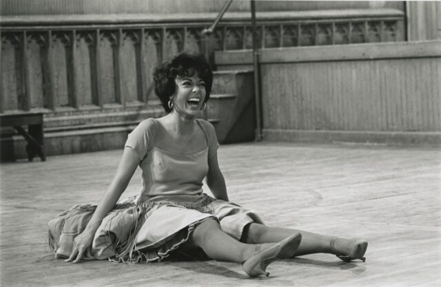 Rita Moreno sitting on the floor, laughing.