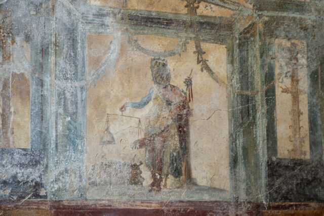 A worn fresco on a wall in Pompeii.
