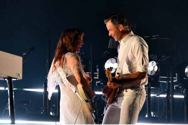 Jenny Lewis and Ben Gibbard playing guitars at each other.