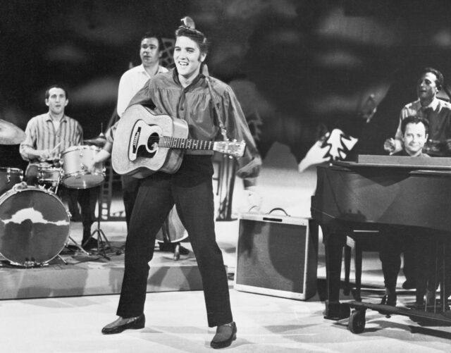 Elvis Presley performing with a band. 