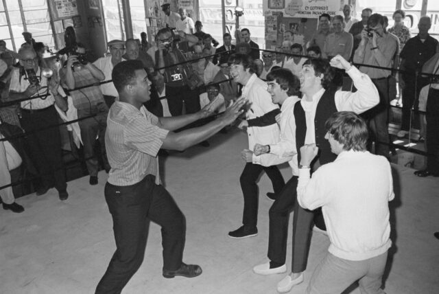 The Beatles raising fists pretending to punch Muhammad Ali.