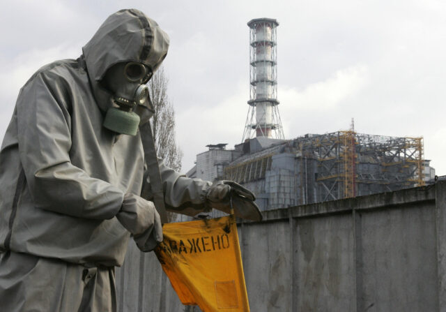 A person in a hazmat suit outside of the Chernobyl factory.