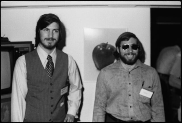 black and white photo of two men, steve jobs and steve wozniak, at computer faire in 1977