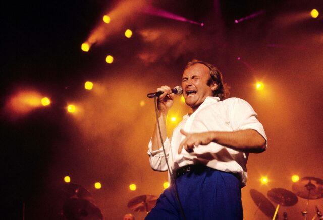 Phil Collins singing into a microphone.