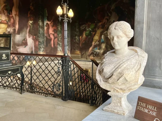 A Roman bust beside a staircase.