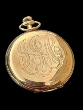 A gold pocket watch with the inscription "JJA."