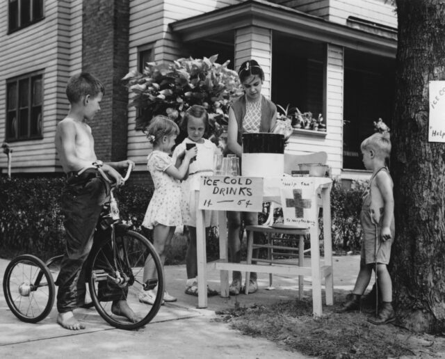 Children selling lemonade at a stand.