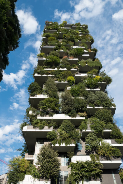 Looking up at the balconies of a tall building with vertical gardens.