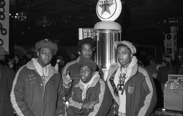 A Tribe Called Quest standing in front of a statue.