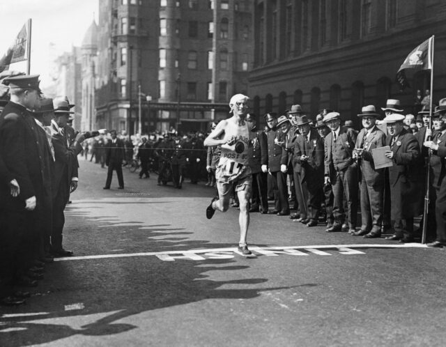 runner clarence de mar crossing finish line as he wins boston marathon in 1927