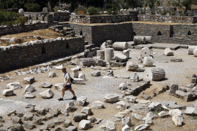 A person walks through the debris of a ruined building.