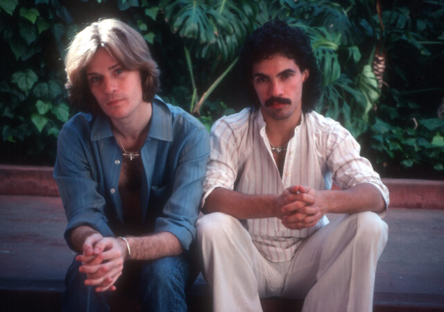 Daryl Hall and John Oates sitting beside one another.