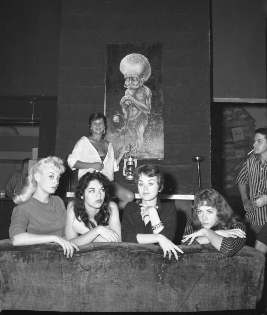 Women sitting and looking out of the back of a couch.