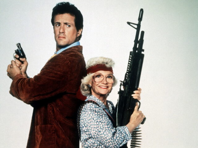 Sylvester Stallone and Estelle Getty standing back to back, both holding guns.