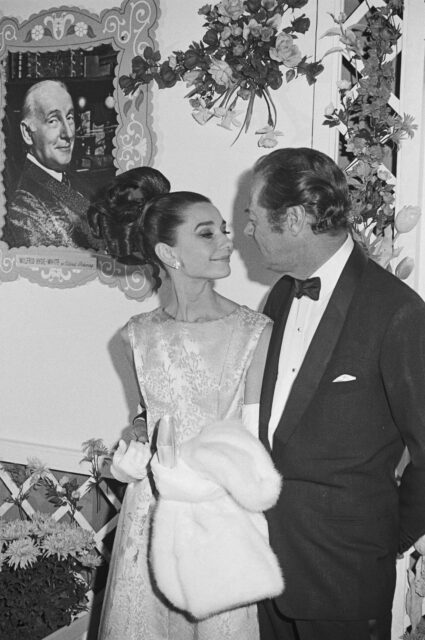 Audrey Hepburn and Rex Harrison looking at one another intimately.