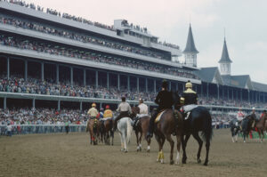 jockeys riding horses on race track at churchill downs 1977