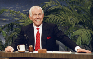 Johnny Carson sitting at a desk.