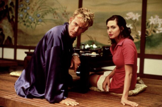 Angelina Jolie and Timothy Hutton sitting on the floor.